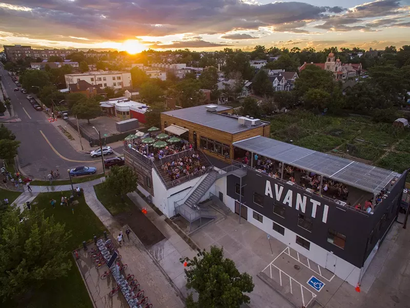 Image: an overhead shot of a building with a rooftop patio during sunset