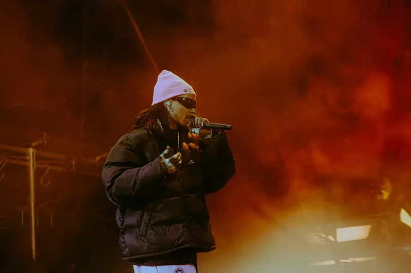 Image: man in pink beanie rapping at a microphone