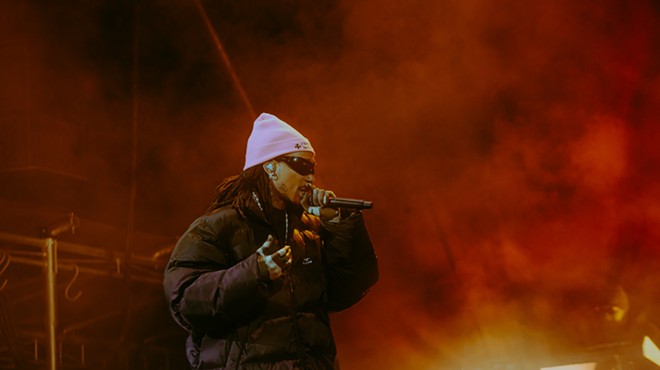 man in pink beanie rapping at a microphone