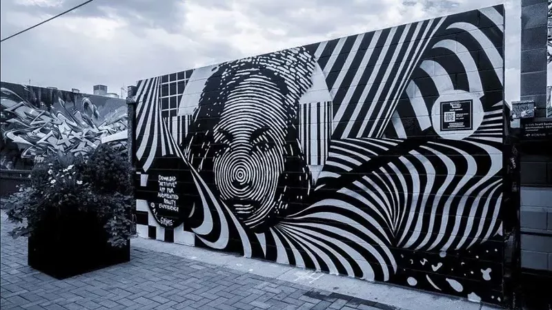 Image: A black and white street art mural in Denver by muralist A.L. Grime