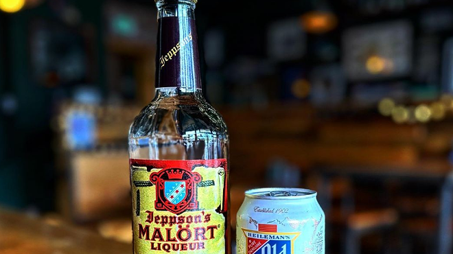 a bottle of liquor next to a can of beer