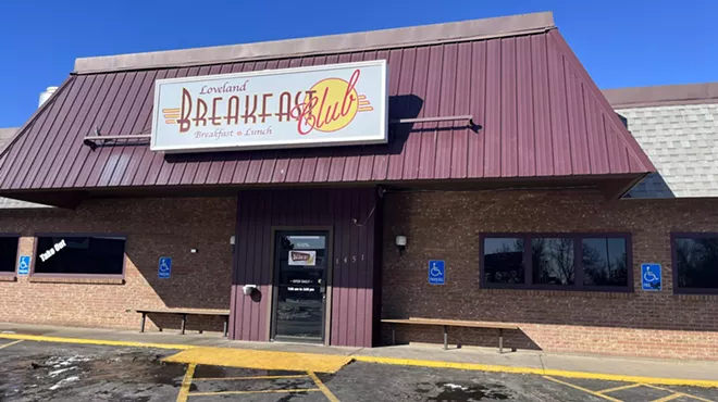 front of a diner with a 'breakfast club" sign
