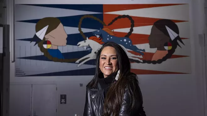 woman in leather jacket in front of art