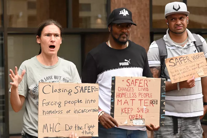 Image: Activists hold up signs.
