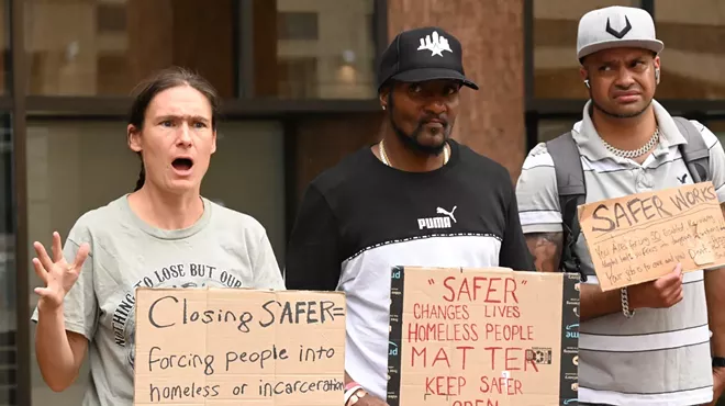 Activists hold up signs.