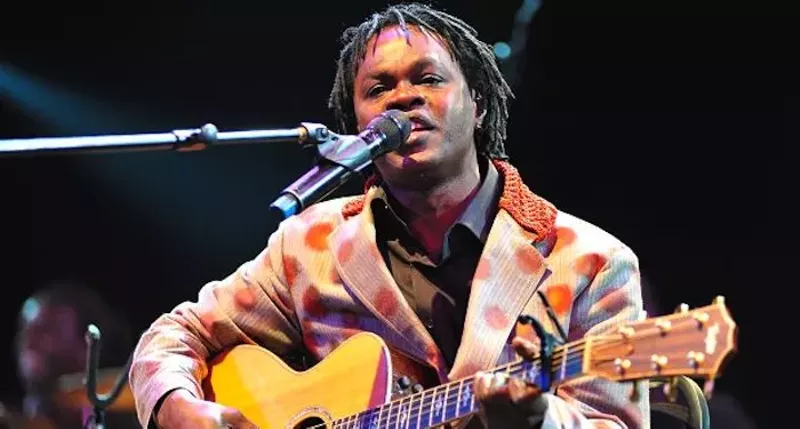 Image: singer on stage with a guitar.