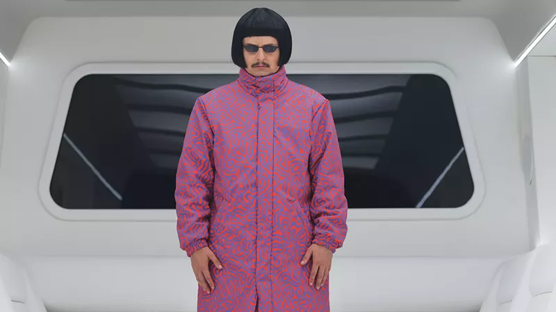Image: musician with bowl cut in a pink jacket