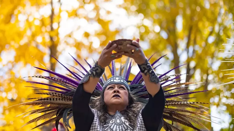 Image: A member of Grupo Huitzilopochtli dances among the trees in Breckenridge.