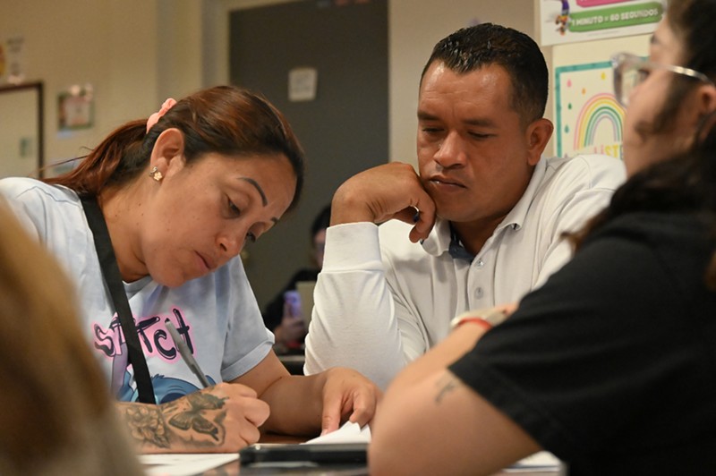 Rony Blanco and Yenire Cirilo sign the paperwork to join the Denver Asylum Seekers Program.