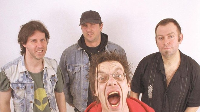 punk musicians posing for a photo against a pale pink background