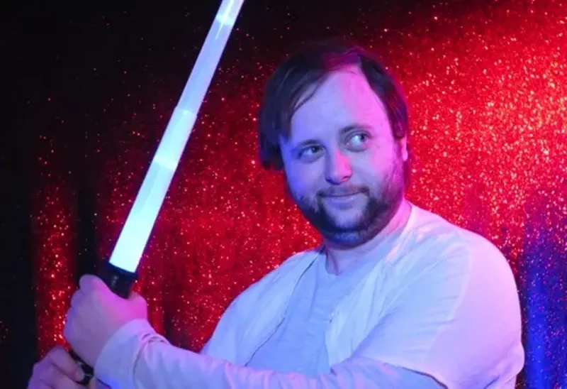 Image: man holding lightsaber
