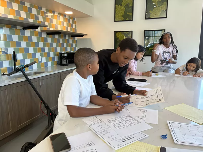 Image: A teenager tutors a younger kid.