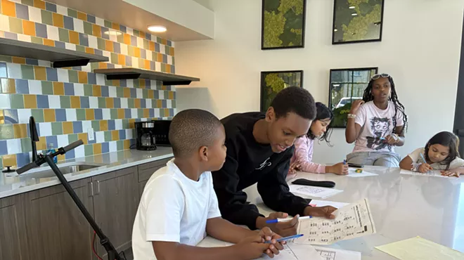 A teenager tutors a younger kid.