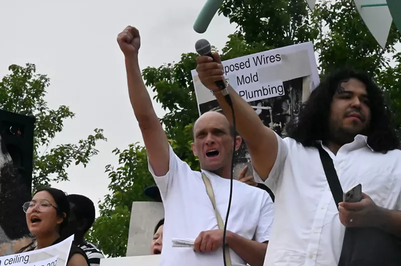 Image: Michael Lunsford holds up his fit alongside other protesters at a rally at Fletcher Plaza in Aurora.