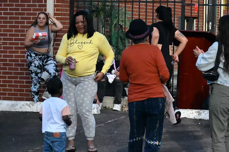 Image: A woman dances with a kid.