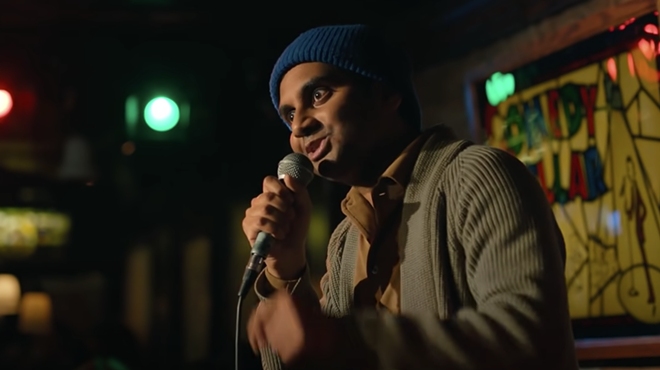 man in blue beanie talking into a microphone
