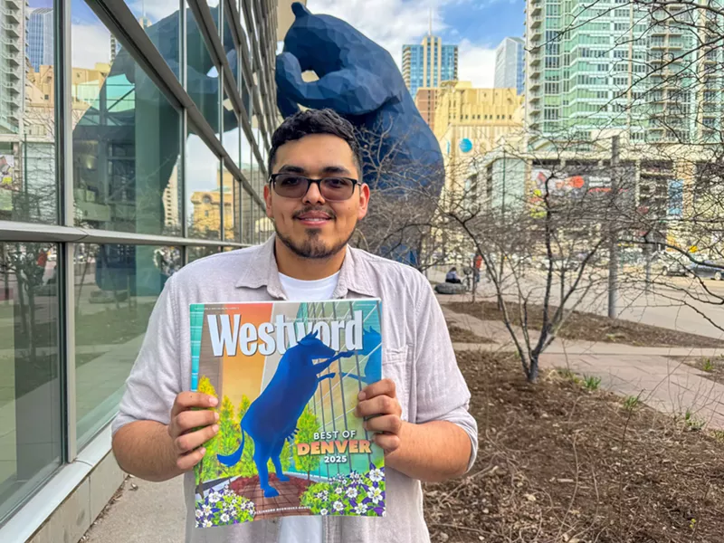 Image: man holding paper by big blue bear