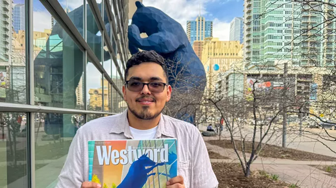 man holding paper by big blue bear