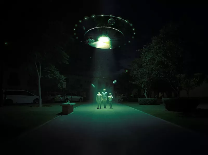 Image: Aliens stand under a green light