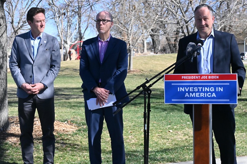 Mayor Mike Johnston listens to Doug Emhoff, the second gentleman, alongside U.S. Intergovernmental Affairs Director Tom Perez at Argo Park during a press conference on Thursday, March 21.
