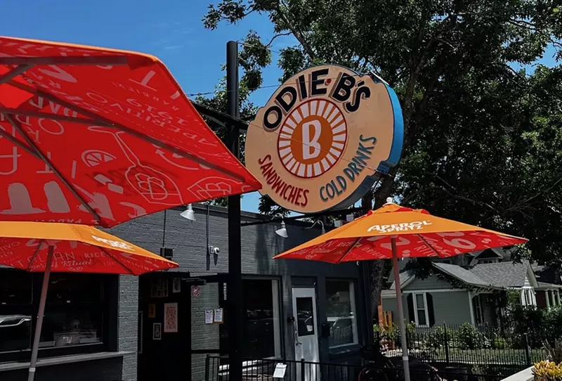 Image: orange umbrellas on a patio and a sign that says "odie b's"