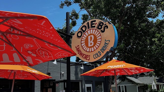 orange umbrellas on a patio and a sign that says "odie b's"