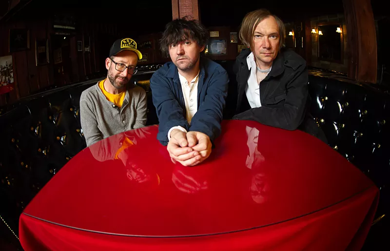 Image: Bright Eyes' Mike Mogis, Conor Oberst, Nate Walcott are pictured sitting at a red table