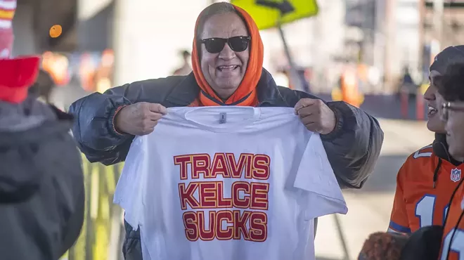 Denver Broncos fans holds Travis Kelce Sucks t shirt