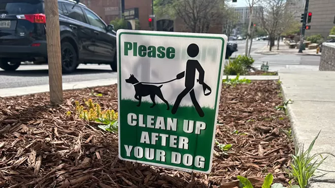 dog poop clean up sign on sidewalk