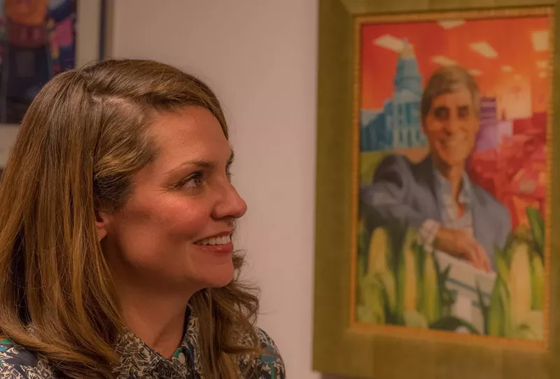 Image: Amanda Sandoval smiling at a photo of her late father, Paul Sandoval.