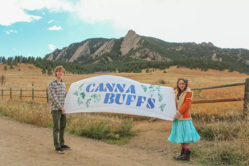 Image: College students hold a CannaBuffs banner in front of Colorado mountains