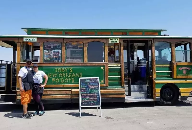 Image: The owners in front of their trolley...we mean food truck.