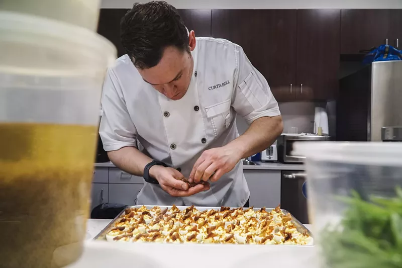 Image: man in a chefs coat preparing food
