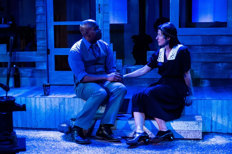 Image: two actors on stage under blue lighting