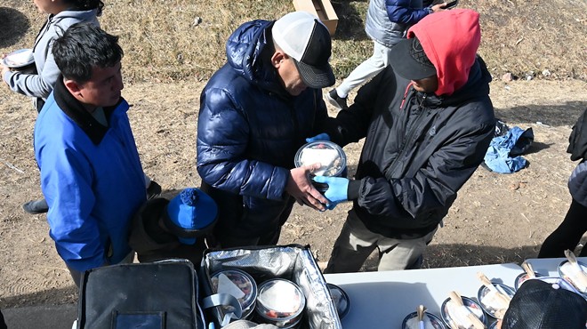 Migrants pick up a lunch in Denver.