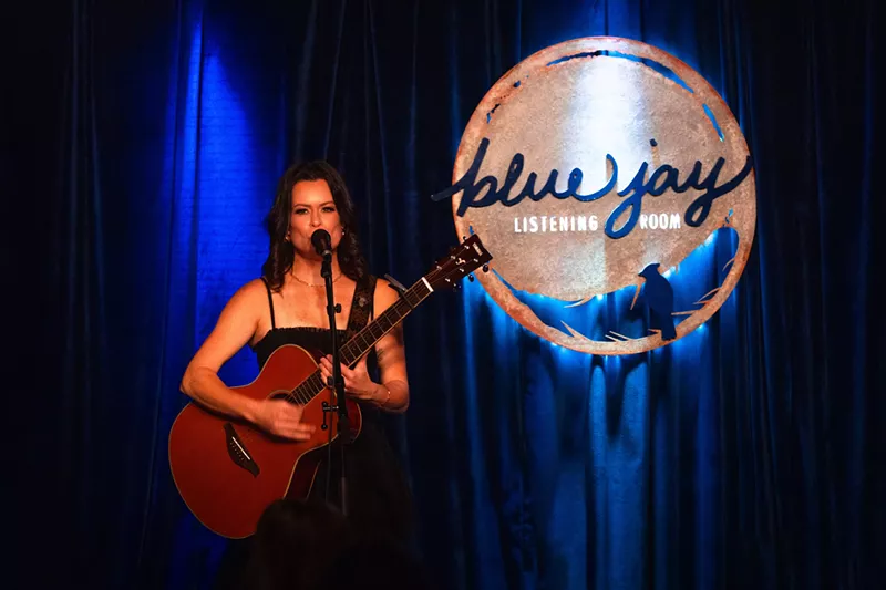Image: woman with guitar singing