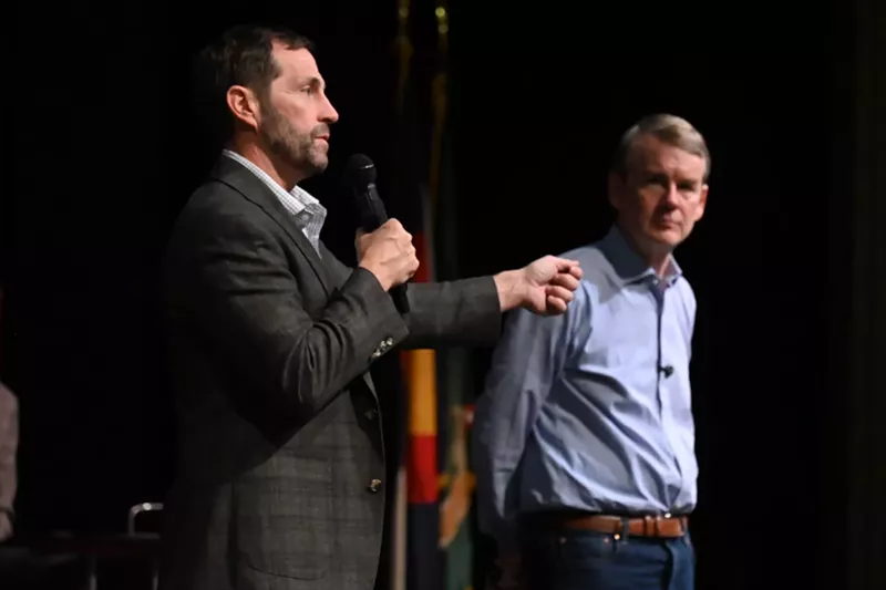 Image: Two guys talk on stage.