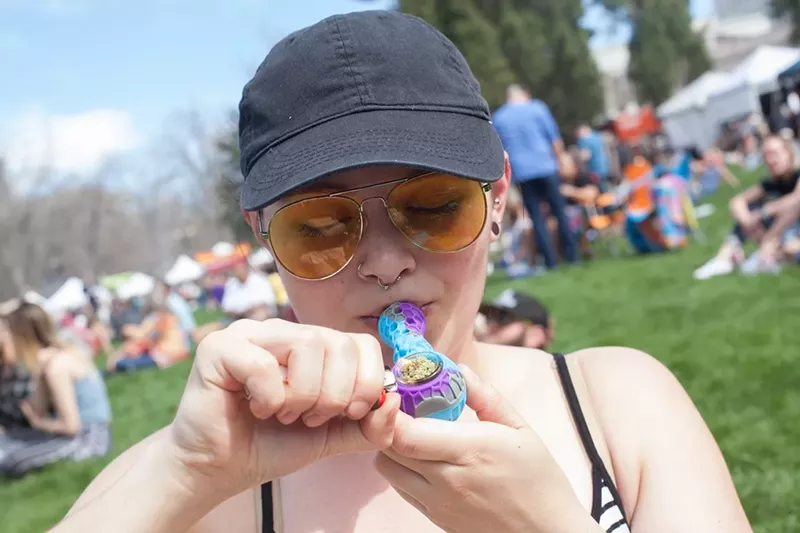 Image: Woman smokes marijuana out of pipe at park