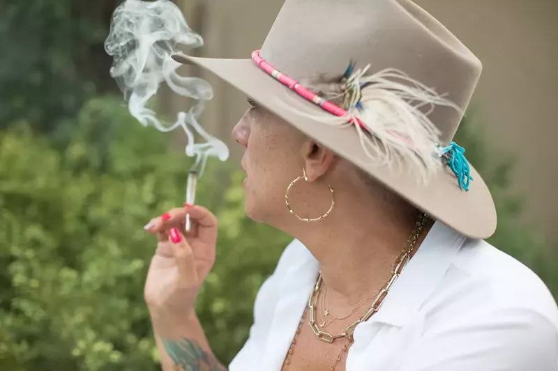 Image: woman in hat smokes joint