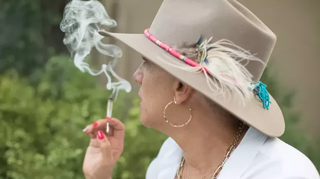 woman in hat smokes joint