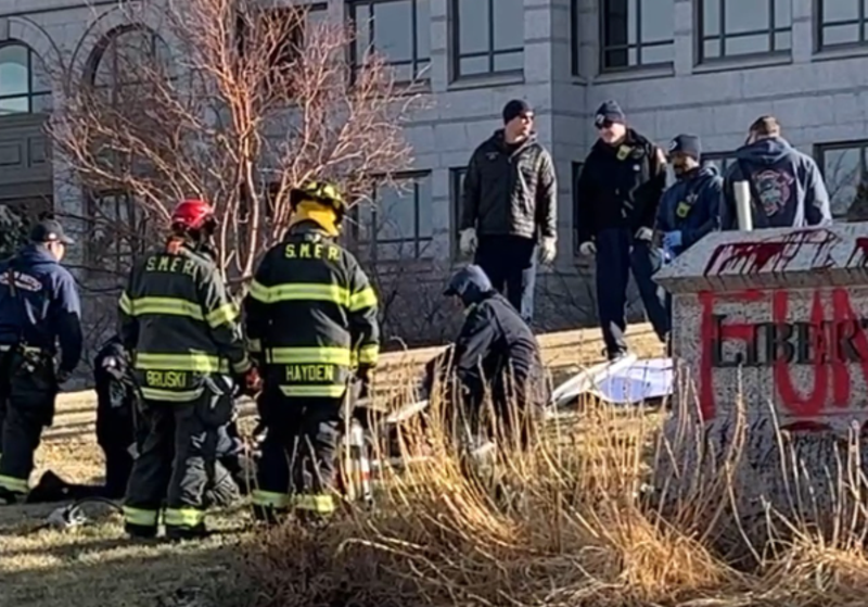 Image: Firefighters use a power tool.