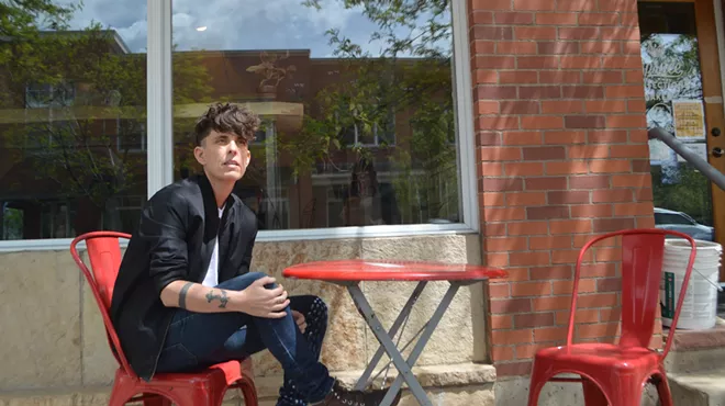 Andrea Gibson sits at a red table