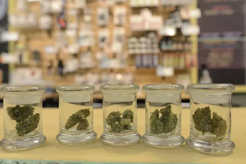 Image: Cannabis flower jars inside Boulder dispensary Helping Hands