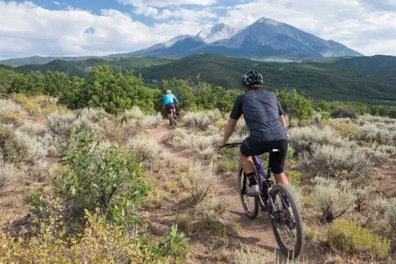 Image: People riding mountain bikes on trail in Colorado
