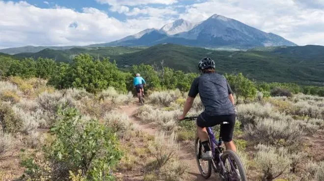 People riding mountain bikes on trail in Colorado