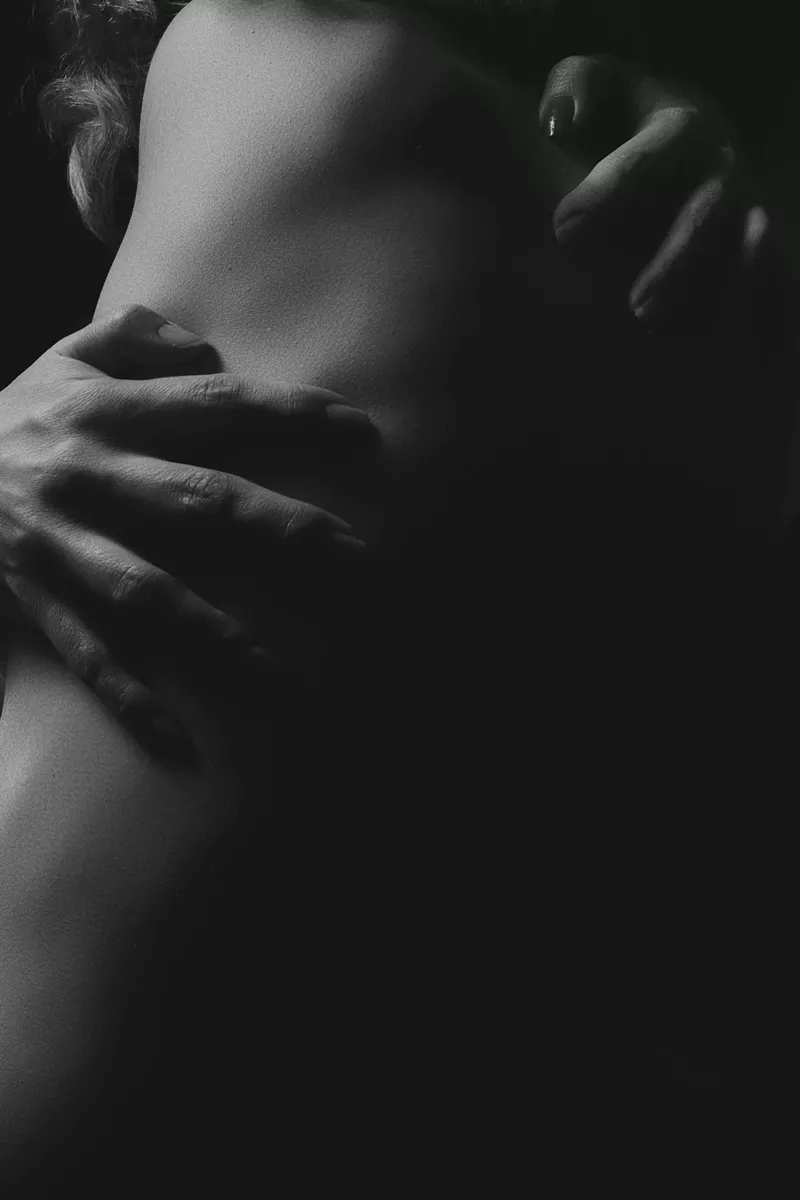 Image: A black and white photo of hands hugging a body