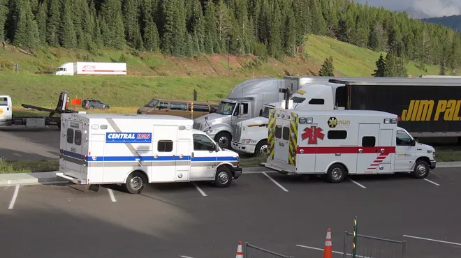 two ambulances parked in front of trees in the Colorado mountains