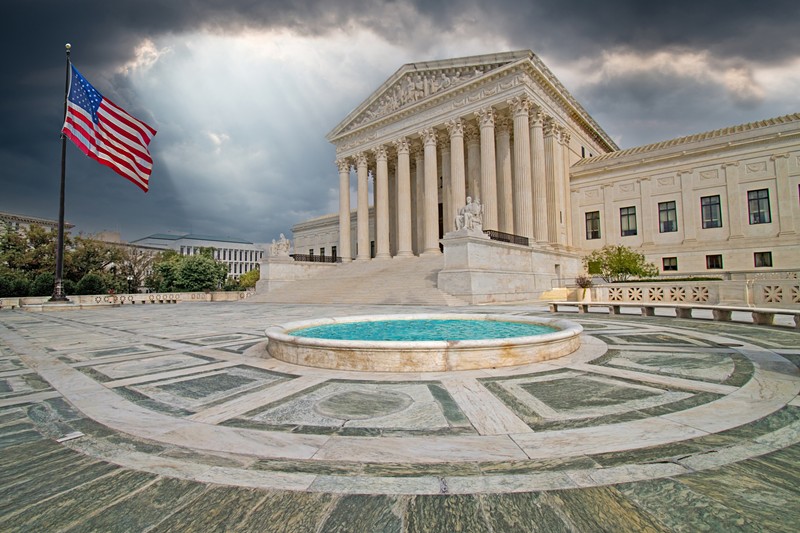 supreme court building with flag and light from heaven