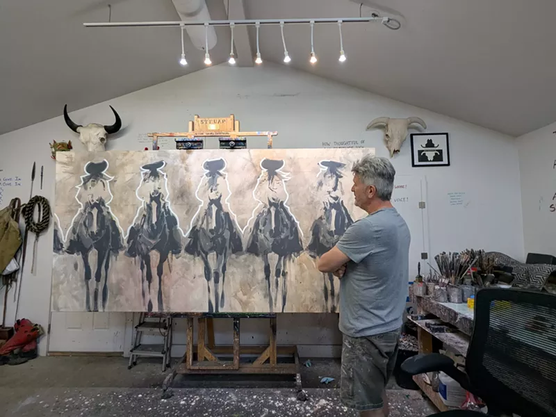 Image: A man looks at his artwork