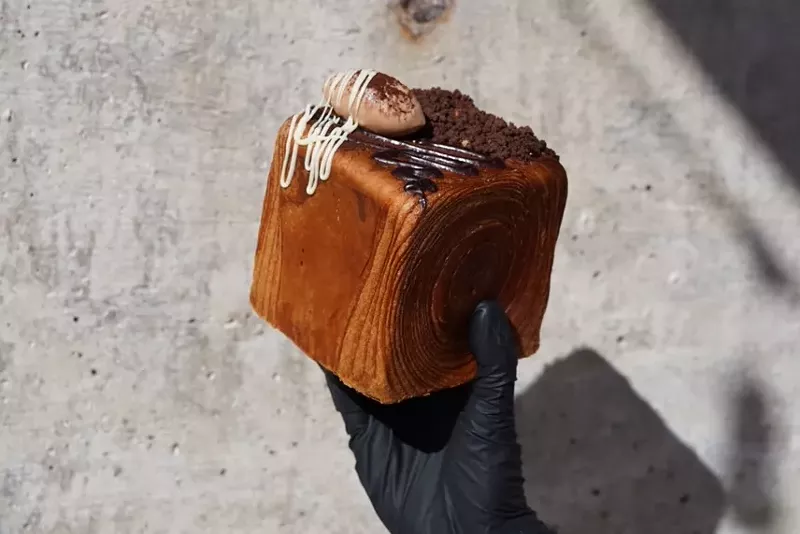 Image: hand holding a croissant cube